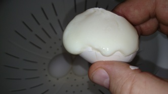 Carefully opening the egg.